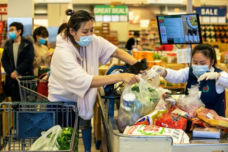 Getty/The Boston Globe/Stan Grossfeld Customers and cashiers wear face masks at a supermarket in Quincy, Massachusetts, on March 13, 2020.