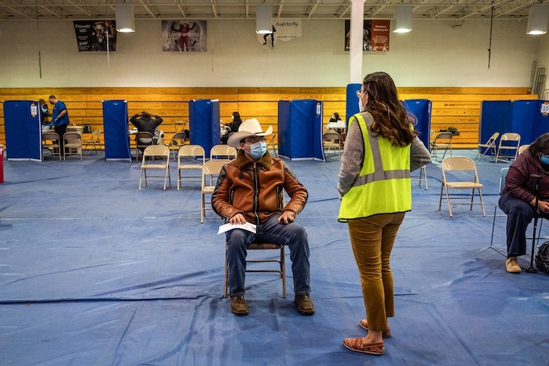 A volunteer, right, speaks with a person who received a Covid-19 vaccine shot at the University of New Mexico's Gallup campus in Gallup, N.M., on March 23.Cate Dingley / Bloomberg via Getty Images file