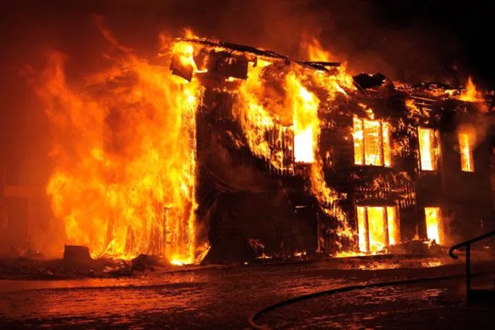 building engulfed in flames at night