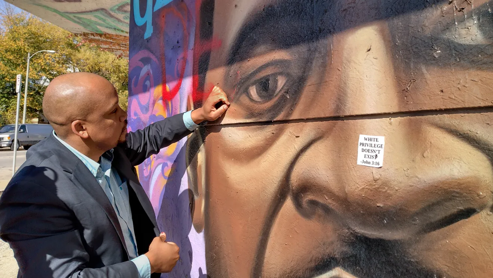 community activist Samuel Alford scratches paint off mural by La Risa Lynch, Milwaukee Journal Sentinel