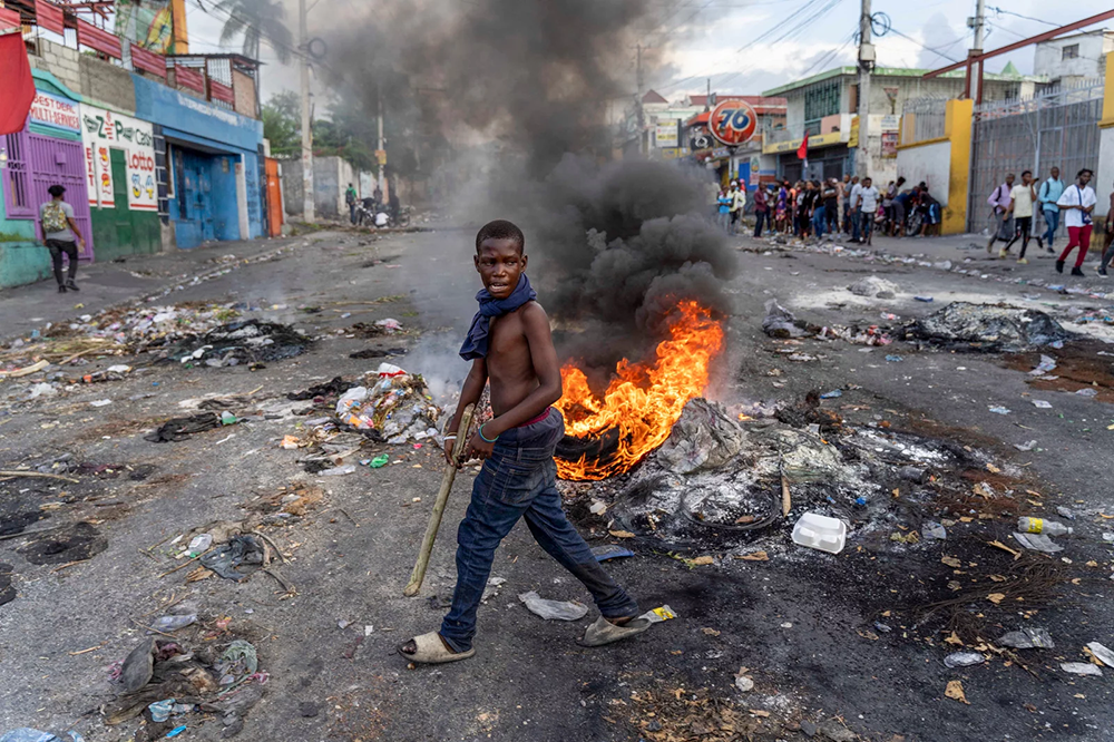 A barricade burns in Port-au-Prince during a protest against Haitian Prime Minister Ariel Henry, with demonstrators calling for his resignation.