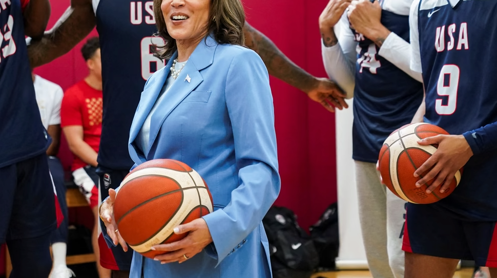 Kamala Harris holding a basketball among basketball players
