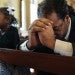 black father and daughter praying in pews