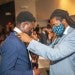 Calvin Hadley, assistant provost for academic partnerships and student engagement at Howard University, helps a business school student put on a tie as part of a ceremony for the You Lead Male Initiative, a support program for Black men business students.
